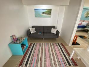 MataveraShineAwayHomes -AC Beachfront RAROTONGA的客厅配有沙发和桌子