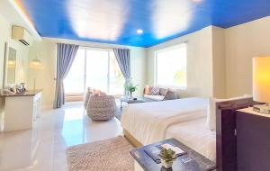 长滩岛长滩岛海洋俱乐部海滩度假村的一间卧室设有一张床和蓝色的天花板