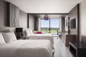 曼谷曼谷素万那普艾美高尔夫水疗度假酒店的酒店客房设有两张床和电视。