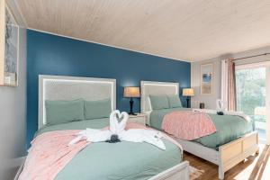 巴拿马城海滩Boho Bungalow的卧室设有两张床铺和蓝色的墙壁
