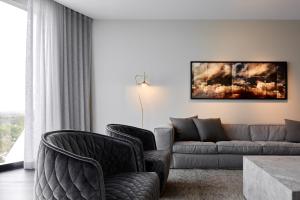 阿德莱德Eos by SkyCity的客厅配有沙发和两把椅子
