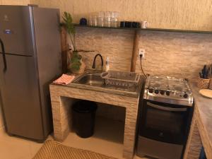 卡姆布库Casita Cumbuco的厨房配有水槽、炉灶和冰箱