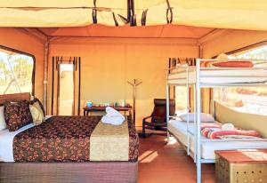 Karijini卡里基尼生态度假酒店的一间带床铺和双层床的巴士卧室