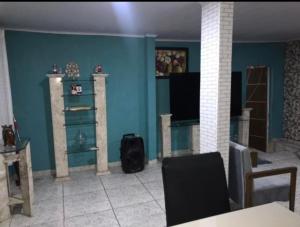 里约热内卢casa alto padrão a 30 min da praia的客厅拥有蓝色的墙壁和桌椅