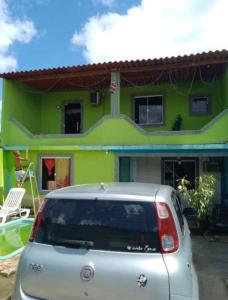 里约热内卢casa alto padrão a 30 min da praia的停在绿色房子前面的汽车