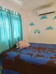 普纳奥亚Fare Cocoon的一间卧室配有一张蓝色窗帘的床