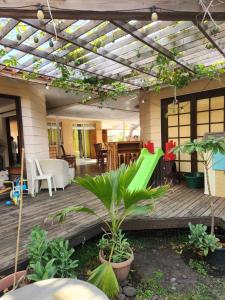 普纳奥亚Fare Cocoon的户外甲板上设有凉棚和一些植物