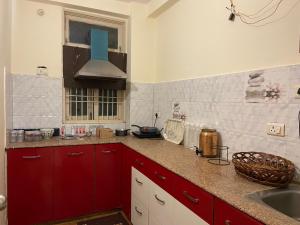瓦拉纳西Kashi Karma Homestay的一间带红色橱柜和水槽的厨房