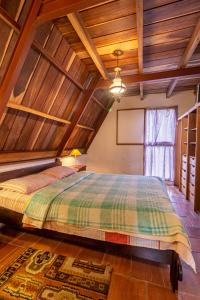 El TigreChalet Lander Colonia Tovar的一间带一张大床的卧室,位于一个拥有木制天花板的房间