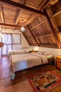 El TigreChalet Lander Colonia Tovar的配有木天花板的客房设有两张床。