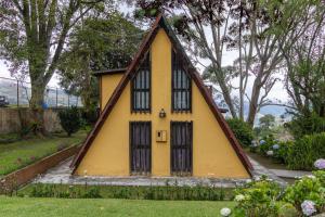 El TigreChalet Lander Colonia Tovar的一座带三角形屋顶的黄色小房子