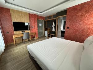 三百岭La Isla Pranburi Beach Resort的一间卧室配有一张床、一张书桌和一台电视