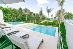 艾库玛尔Casa Blanca By The Caribbean Sea的游泳池旁的游泳池配有躺椅