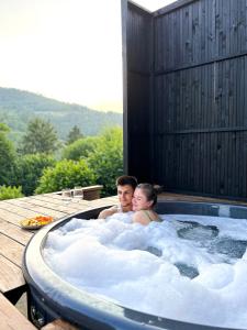 斯拉夫西克Mirest - котедж в горах із чаном-джакузі的坐在热水浴缸中的男女