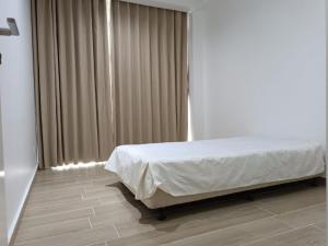 吉隆坡Bintang Goldhill Guest House的一间卧室配有床和带窗帘的窗户