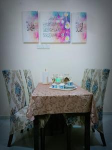 峇株巴辖HOMESTAY Duranta Home's的餐桌、两把椅子、一张桌子和一张桌布