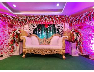 DarbhangaHotel Grand SM Regency, Darbhanga的花墙房间内的白色沙发