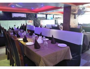 DarbhangaHotel Grand SM Regency, Darbhanga的用餐室配有带紫色桌布的桌子
