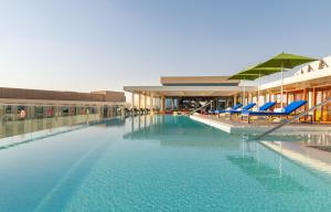 艾恩艾恩雅乐轩酒店的一座带蓝色椅子的游泳池和一座建筑