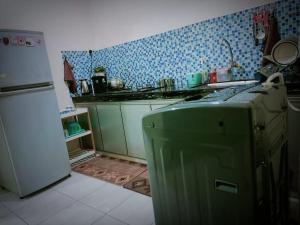 峇株巴辖HOMESTAY Duranta Home's的厨房配有炉灶和冰箱。
