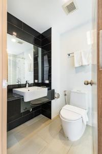 他朗Phuket Airport Condotel的浴室配有白色卫生间和盥洗盆。