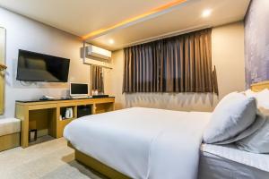 济州市Aliba Hotel的酒店客房,配有床和电视