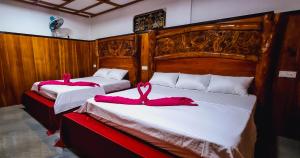 达瓦拉维Maika safari lodge的两张带粉红色毛巾的床。