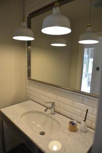 格但斯克Five Point Hostel & Apartments的浴室设有水槽、镜子和灯