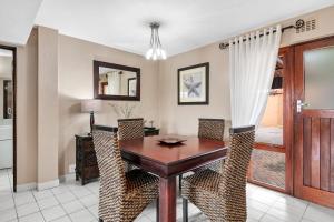 绍斯布鲁姆San Lameer Villa 2826 - 2 Bedroom Classic - 4 pax - San Lameer Rental Agency的一间带木桌和椅子的用餐室