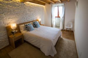 圣地亚哥－德孔波斯特拉Casa Juancito的一间卧室设有一张床和石墙