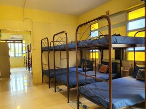 古晋SPOT ON 90856 Arriva Travellers的客房设有三张双层床,配有蓝色床单