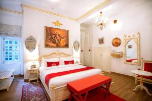 斋浦尔The Royal Hermitage - Best Luxury Boutique Hotel Jaipur的卧室配有白色大床和红色长凳