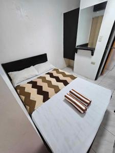 长滩岛Villa Tomasa Boracay Dmall的房间里的一张床位,上面有两条毛巾
