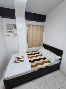 长滩岛Villa Tomasa Boracay Dmall的一间卧室配有一张带黑白色棉被的床