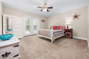尼斯维尔Niceville Dream Home Sleeps 13的一间卧室配有婴儿床、桌子和吊扇。