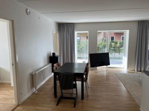 奥尔堡Charming Aalborg Apartment With parking的一间带桌子和电视的用餐室