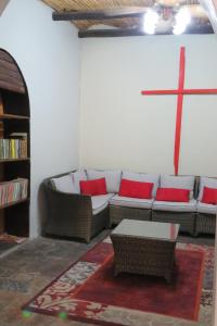 奥乔Faith City Guesthouse的客厅配有沙发和墙壁上的十字架
