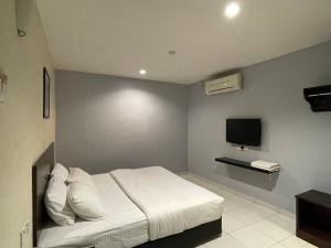 Kampong Batu TigaM Three Hotel by SECOMS的卧室配有白色的床和电视