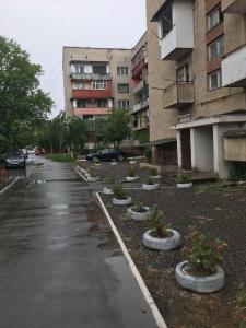 别列戈沃Чудесная квартира в изюминке города Берегово的一个空置的停车场,有盆栽植物和建筑