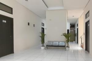 雅加达Urbanview Hotel Residence 446 Tanjung Duren的大楼内带长凳和植物的走廊