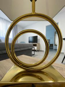 梅里达Apartamentos Lusitania Parking Gratis bajo disponibilidad的客厅桌子上的金色镜子