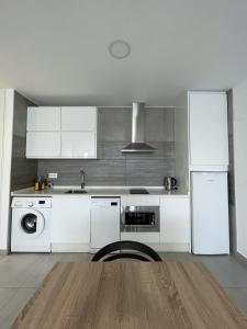 梅里达Apartamentos Lusitania Parking Gratis bajo disponibilidad的厨房配有白色橱柜、水槽和洗碗机。