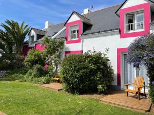 索宗奥克斯塔瑞酒店的粉红色和白色的房子,院子里设有长凳