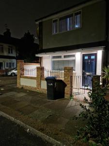 伦敦Stylish 2 bed home- short walk to Tottenham Stadium/Stations的前面有垃圾桶的房子