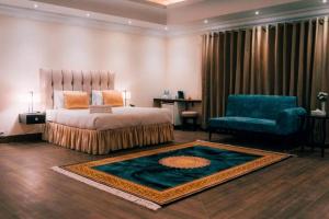 巴哈瓦尔布尔Falettis Grand Bahawalpur的一间卧室配有一张床、一把椅子和地毯