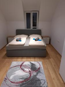 贡特拉姆斯多夫Haus Eichkogel Guntramsdorf的一间卧室配有带两个枕头和地毯的床