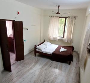 蒂鲁帕蒂Haritha Apartments的一间小卧室,配有床和窗户