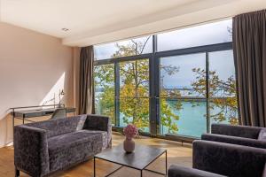 腓特烈港艾卡海滨生活酒店的客厅设有大窗户,享有水景