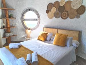 弗里希利亚纳蜗牛乡村酒店的一间卧室配有带白色床单和黄色枕头的床。