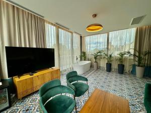 第比利斯Abanotubani Boutique hotel的客厅配有平面电视和绿色椅子。